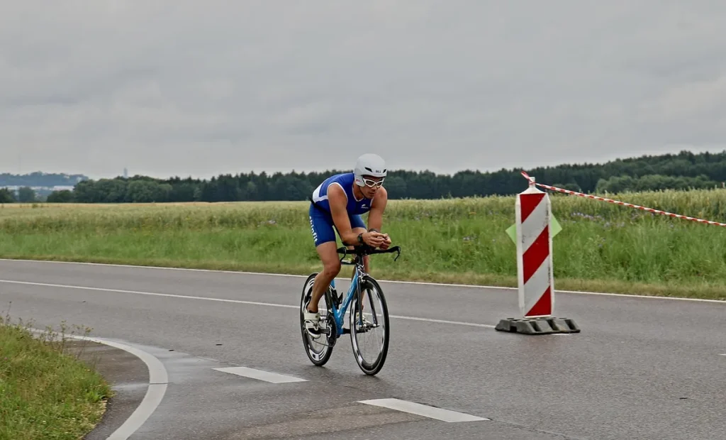 Triathlonista w pozycji aerodynamicznej na rowerze szosowym podczas etapu rowerowego